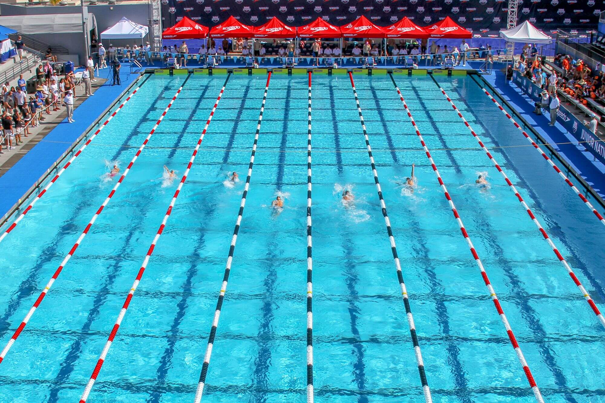 aerial shot of swimmers in a tournament doing laps with spectators on the sidelines at woollett aquatics