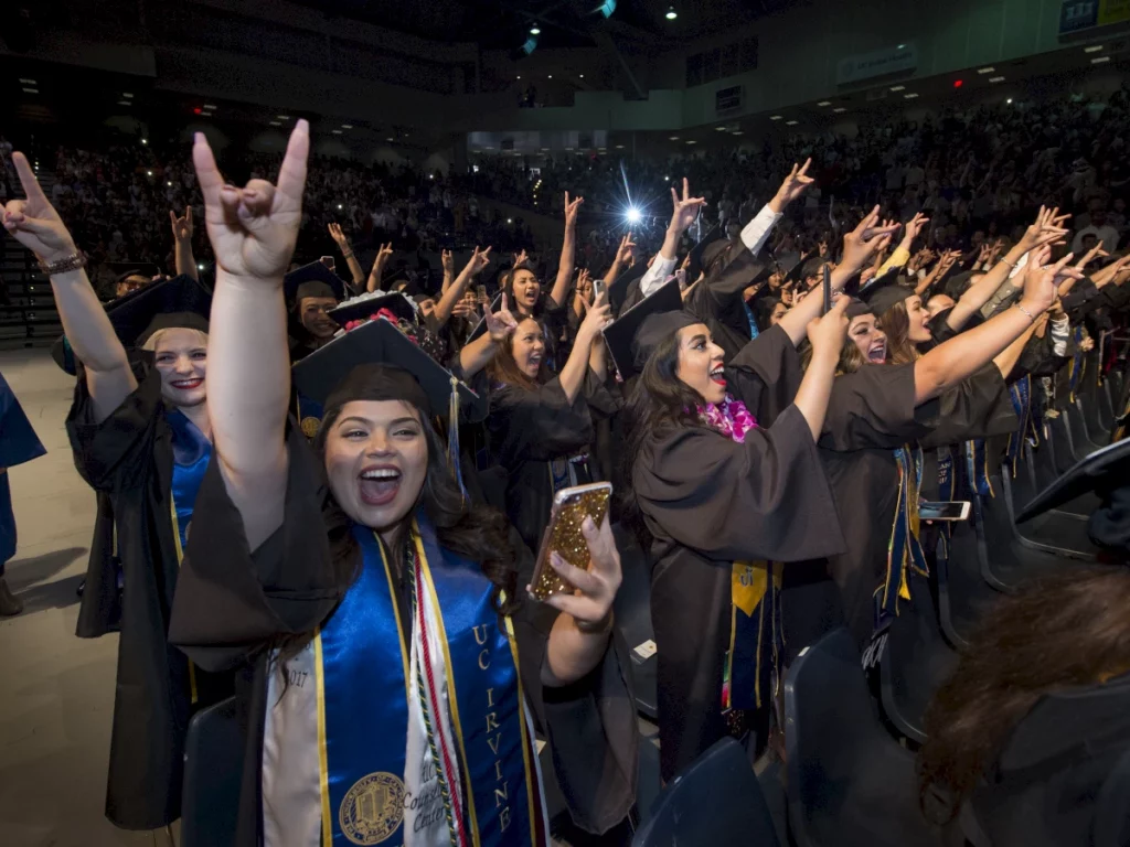 graduates raising their hands