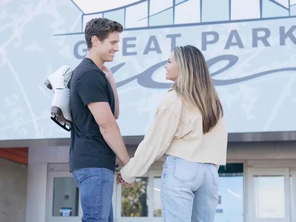 couple looking at each other in front of great park ice skating rink
