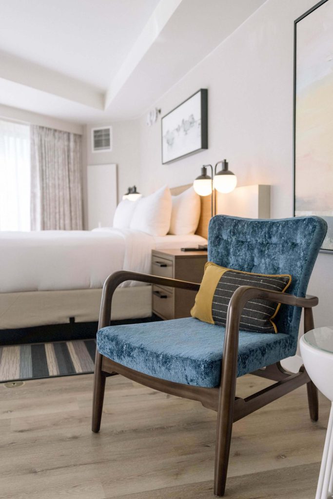 room with bed and blue chair at sonesta hotel irvine