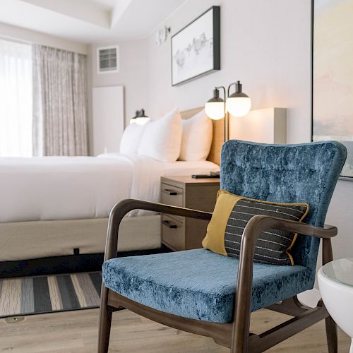 room with white bed and blue chair with pillow at sonesta irvine