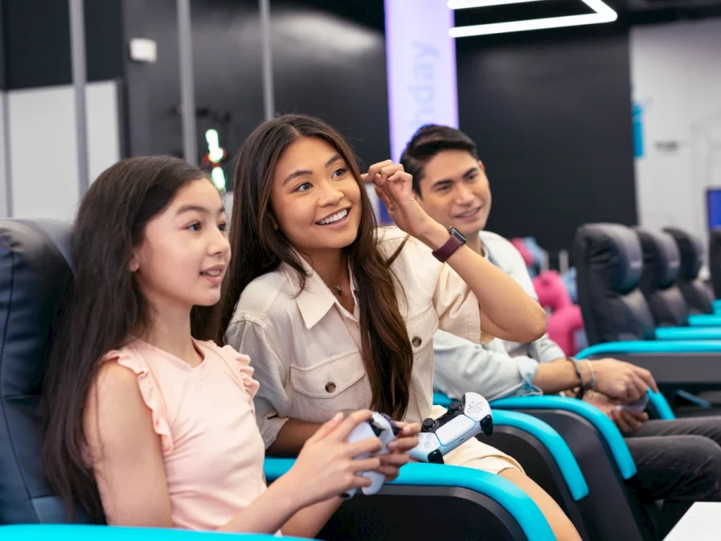 family of three sitting down holding a game console