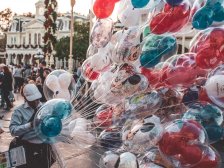 staff selling minnie and mickey mouse balloons in disneyland