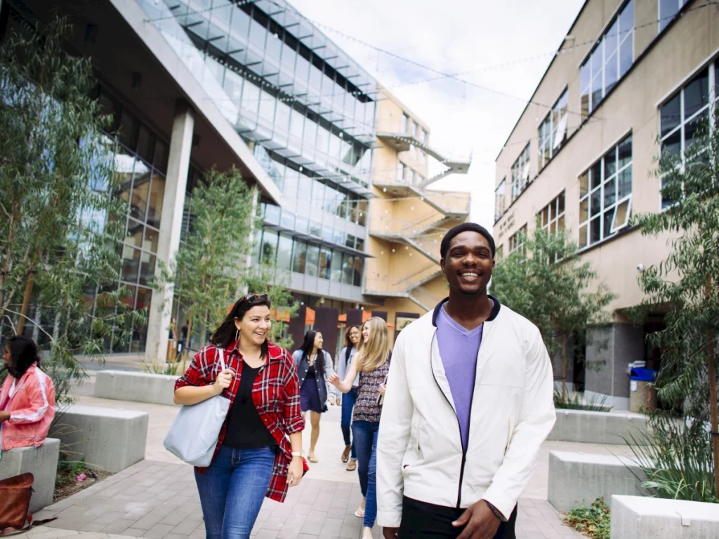 group of students smiling and walking at uc irvine campus