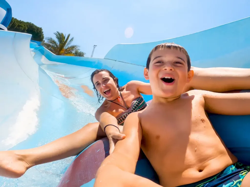 a woman and boy sliding down a waterslide