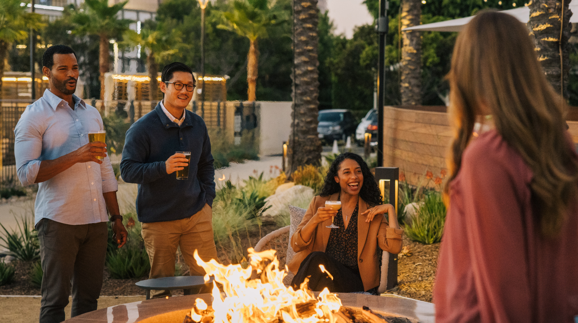 Group enjoying drinks around a fire pit
