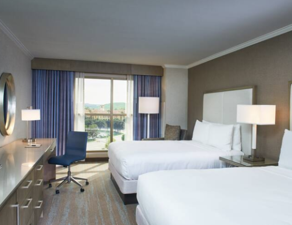 hotel room with blue chair and two white beds at doubletree spectrum