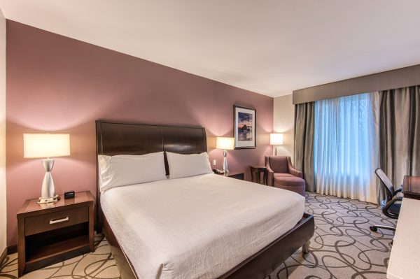hotel room with one king size bed, lamp, table stand, chair lounge at hilton garden inn in irvine