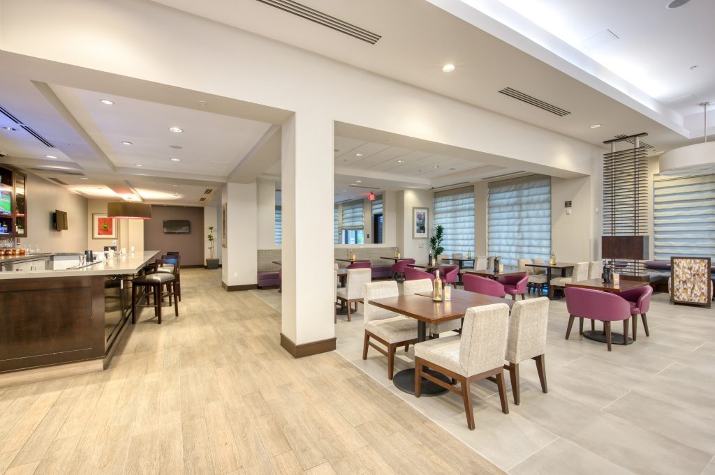 Hilton Garden Inn Irvine restaurant and bar showing bar area with bar stools and tables and chairs