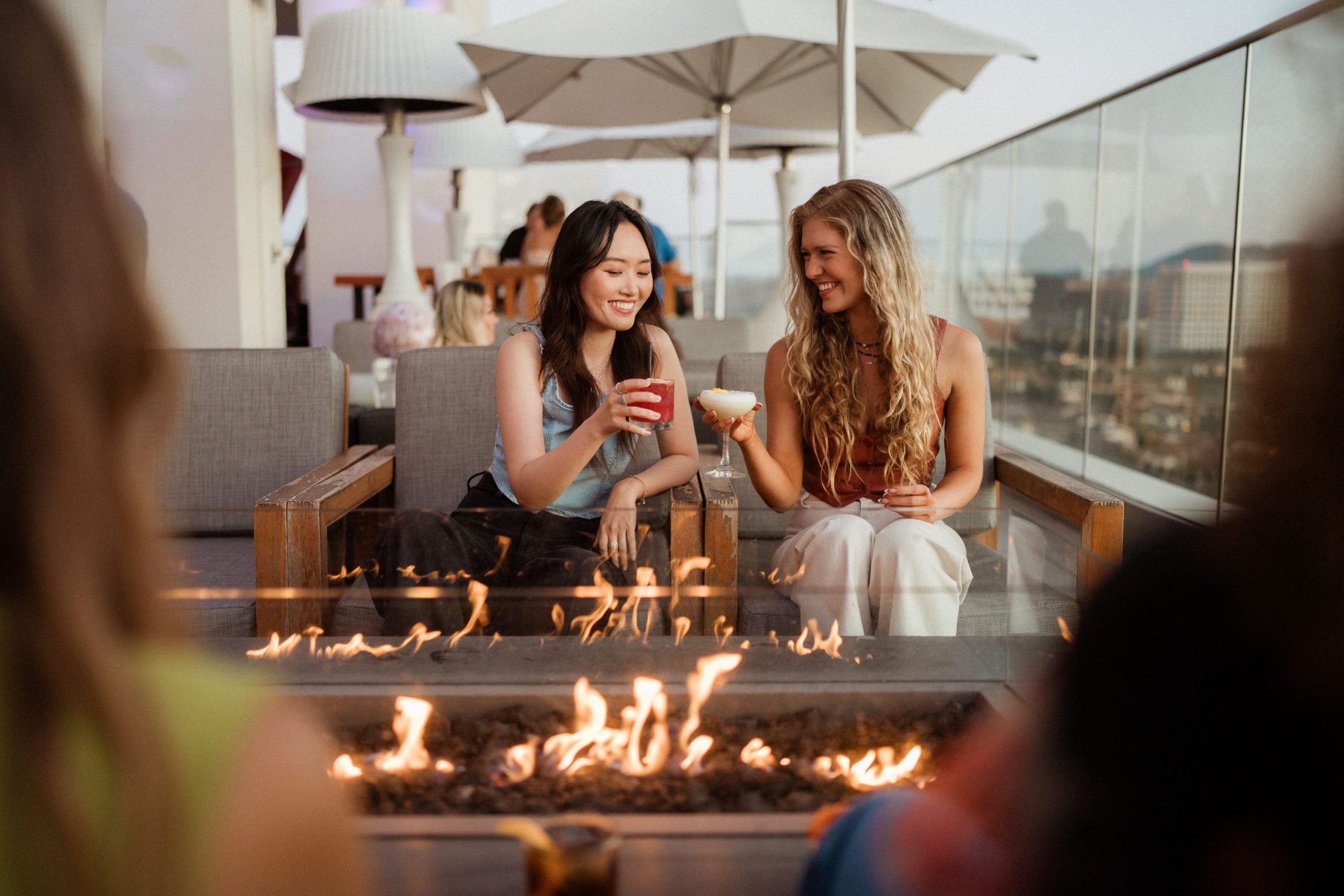 two girls having drinks by pitfire at rooftop bar hive and honey in irvine