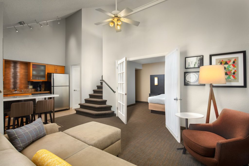 hotel suite with stairs kitchen dining area fridge sink mink kitchen sofa and lamp at residence inn irvine spectrum hotel