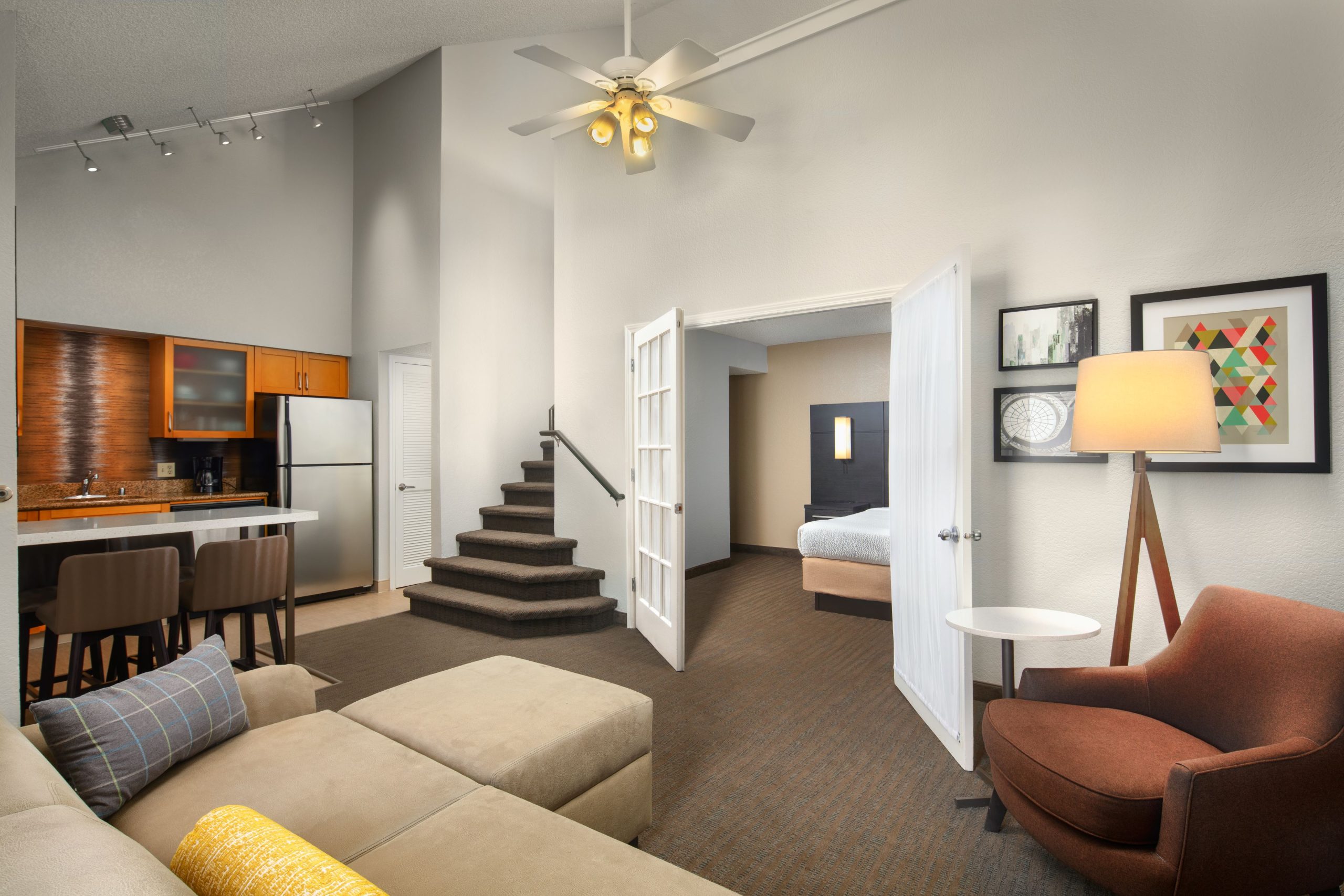 hotel suite with stairs kitchen dining area fridge sink mink kitchen sofa and lamp at residence inn irvine spectrum hotel