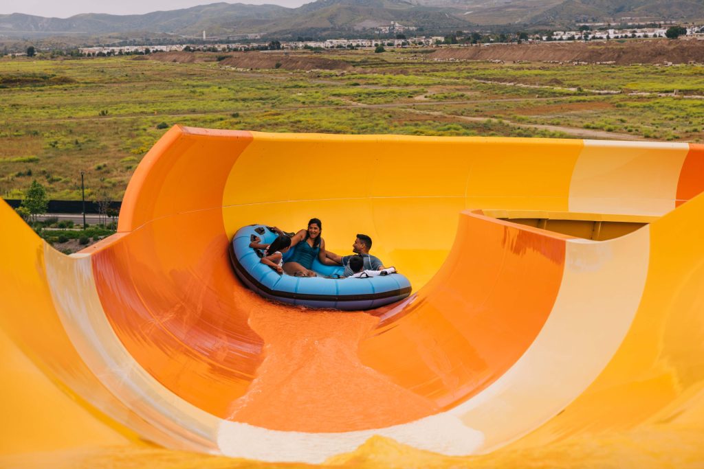 Wild Rivers Water Park Hotel Vacation Package 1 orange water slide with inflatable holding a family of four