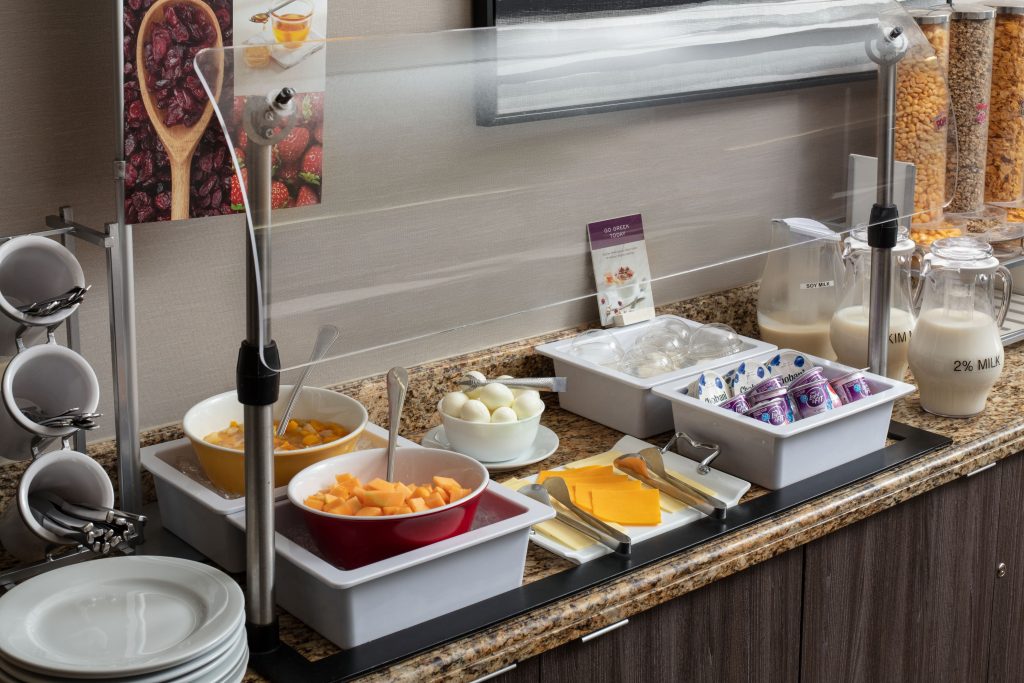 breakfast at residence inn irvine spectrum with milk yogurt cheese eggs and fruits with plates and utensils and cereals