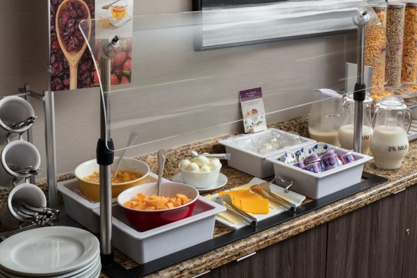 breakfast at residence inn irvine spectrum with milk yogurt cheese eggs and fruits with plates and utensils and cereals