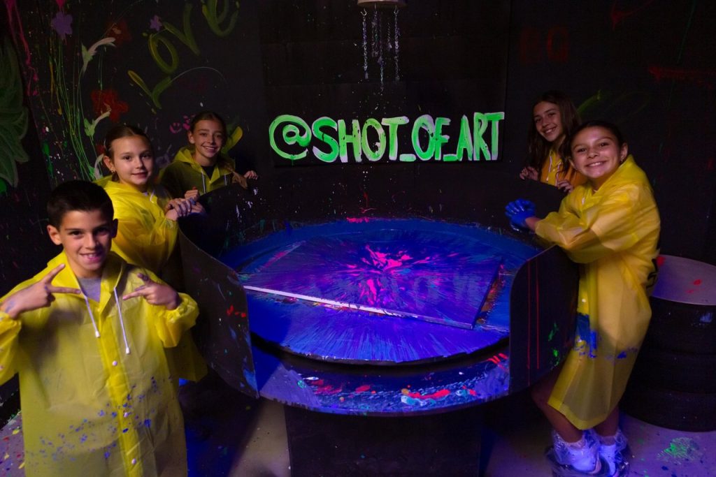 five children in yellow coats smiling at the camera at shot of art irvine