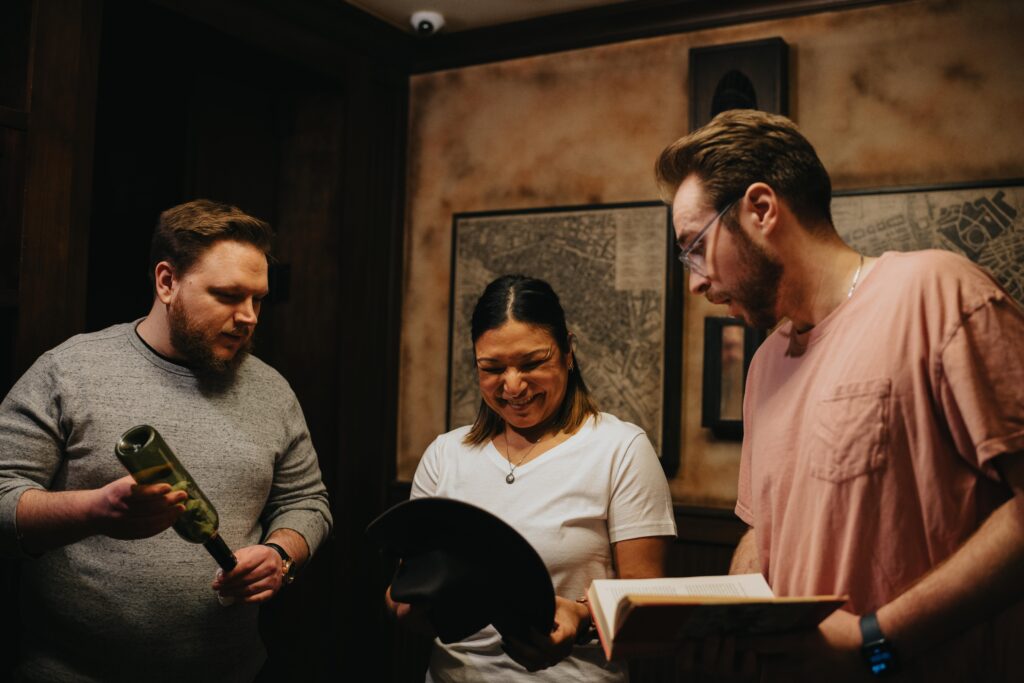 three players with books playing at the heist escape room irvine at the escape game 