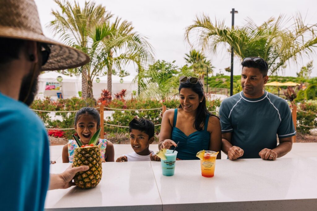 在野河尔湾尽情嬉戏3 family of four at a bar with pineapple and other colorful drinks concoctions at wild rivers