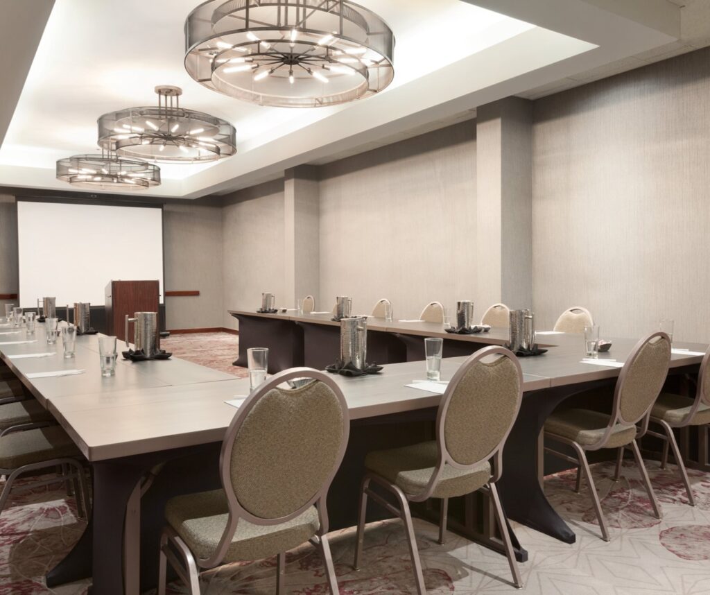 Embassy Suites 7 a meeting room with tables, chairs and chandeliers at embassy suites