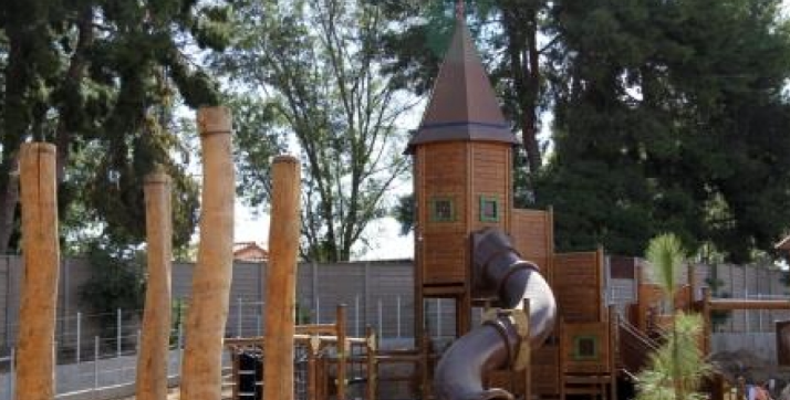 探险游乐场 1 photo of playhouse with tube slide and four wooden posts on the side with trees in the background