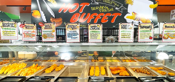 hot buffet spread showing tempura and other fried food with sign at the back saying serving fresh hot buffet