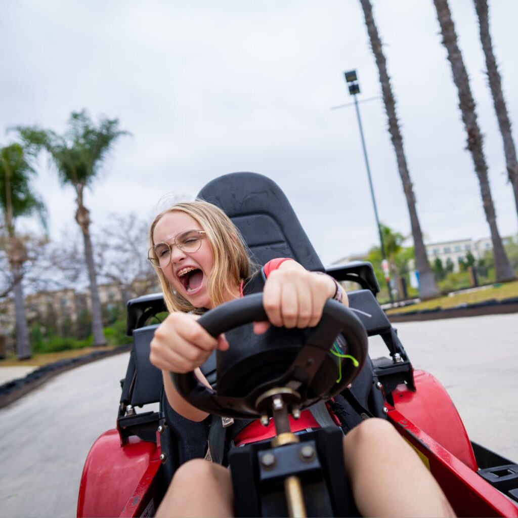 Boomers Irvine 4 blonde girl with glasses with mouth open in a red go kart