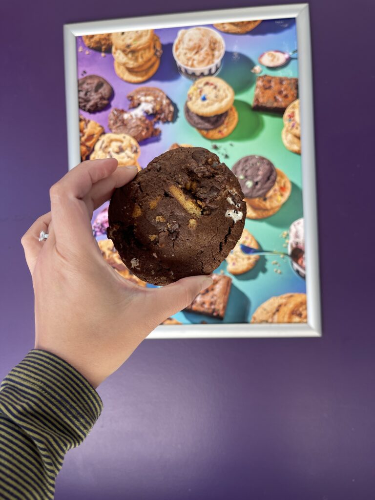 Discover Irvine’s Culinary Scene: From Breakfast to Dessert 4 hand holding a chocolate chip cookie against a picture frame of cookies