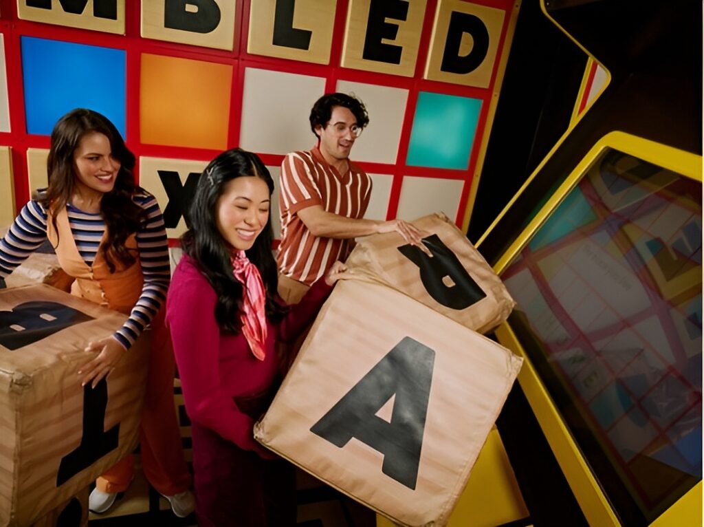 two females and one male each holding a huge letter block