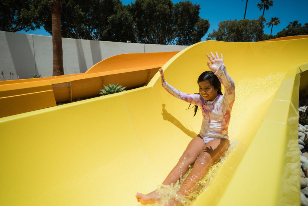 a young girl sliding down a pool slide