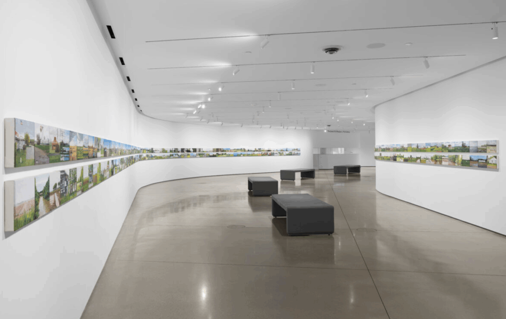 white hall with grey bench and a printed canvas lined on both sides of the wall