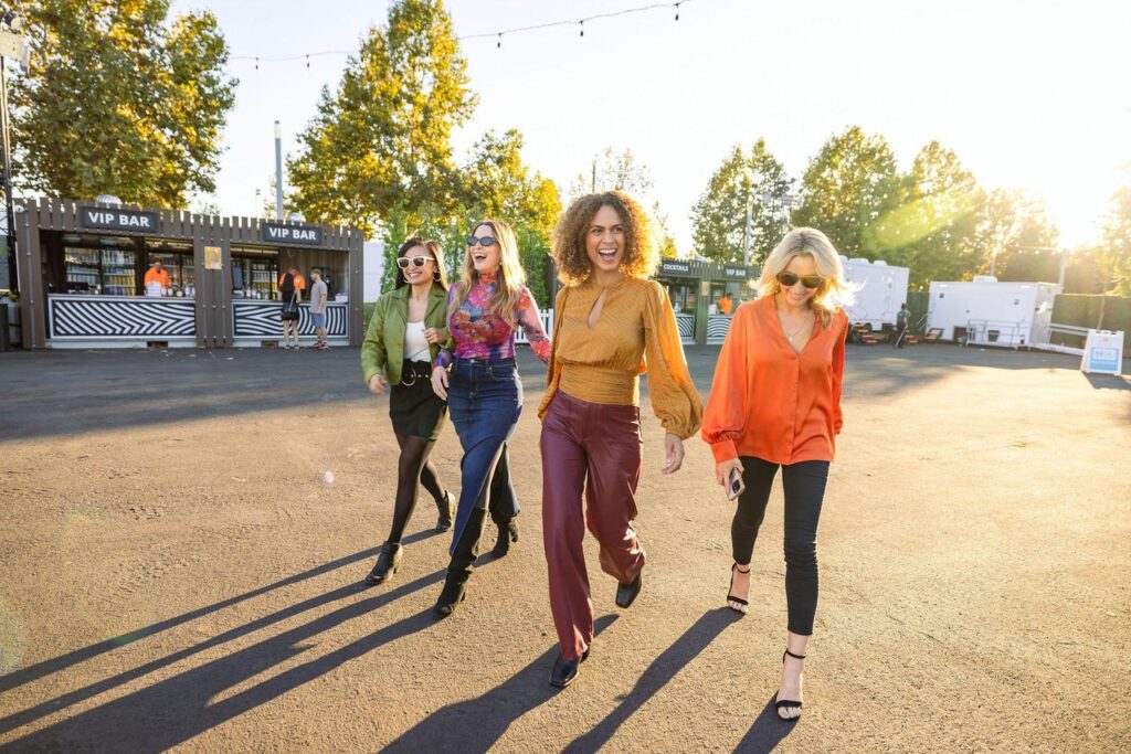 group of four ladies at an outdoor event venue on a sunny day 