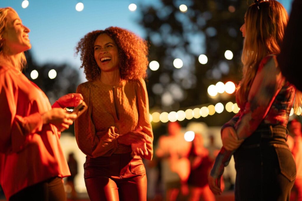 night time photo of three ladies having fun at an outdoor event venue