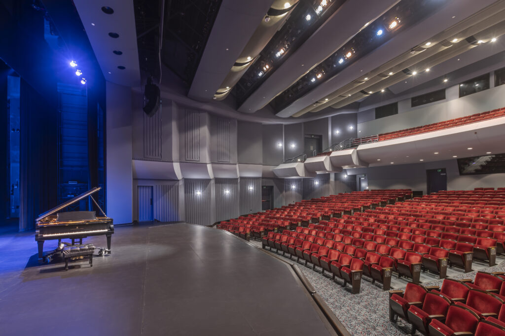 interior theater of cheng hall at irvine barclay theater with red seats and a piano on stage