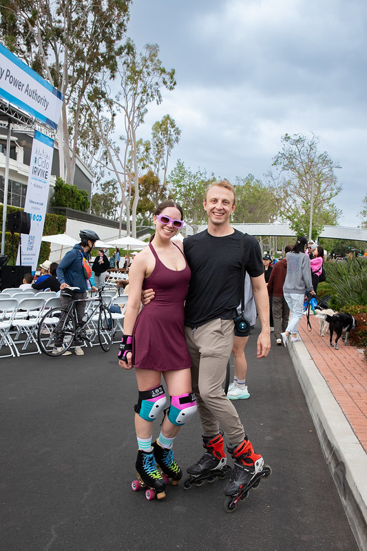 man and woman in red dress in roller blades smiling