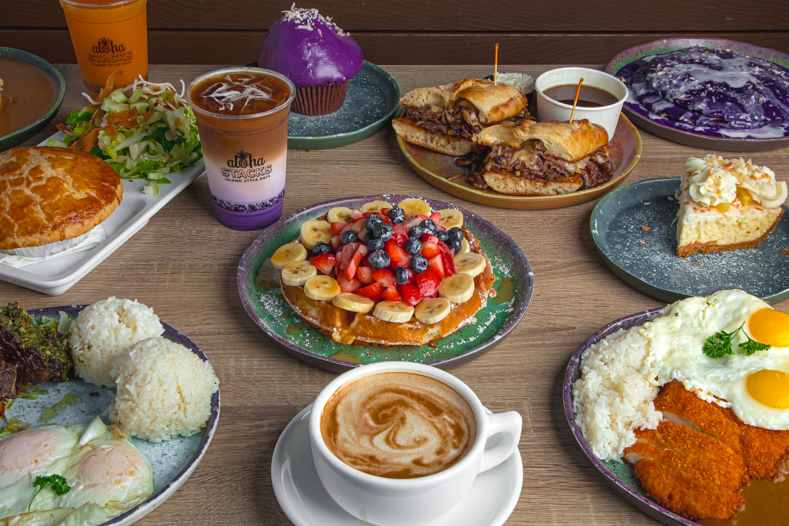 a table filled with plates of food from coffee, ube drink latte, plate of rice, chicken katsudon, eggs, another plate of sandwich, cheesecake, pizza, ube muffin