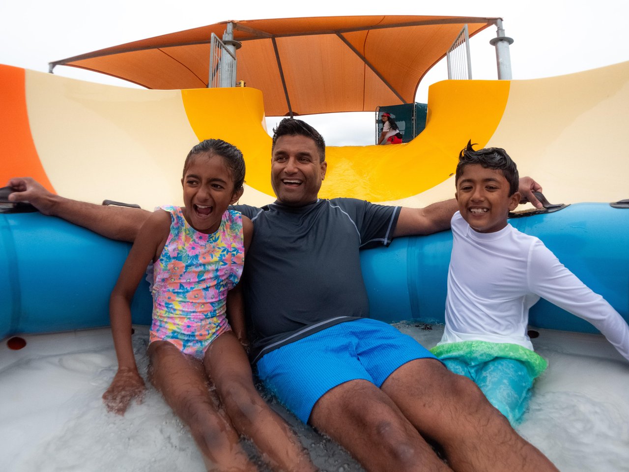 father, daughter and son in an inflatable on a slide at wild rivers waterpark