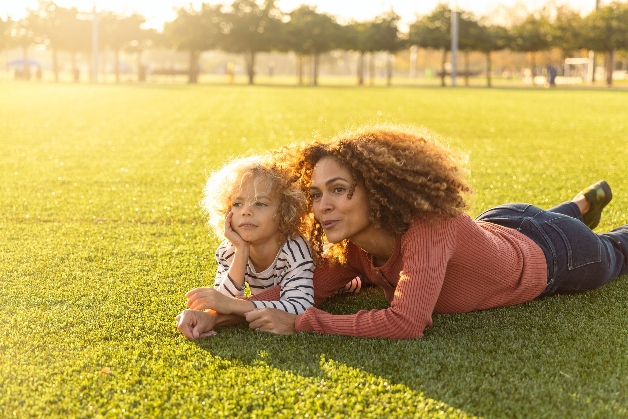 mother and son playing on a grassy field