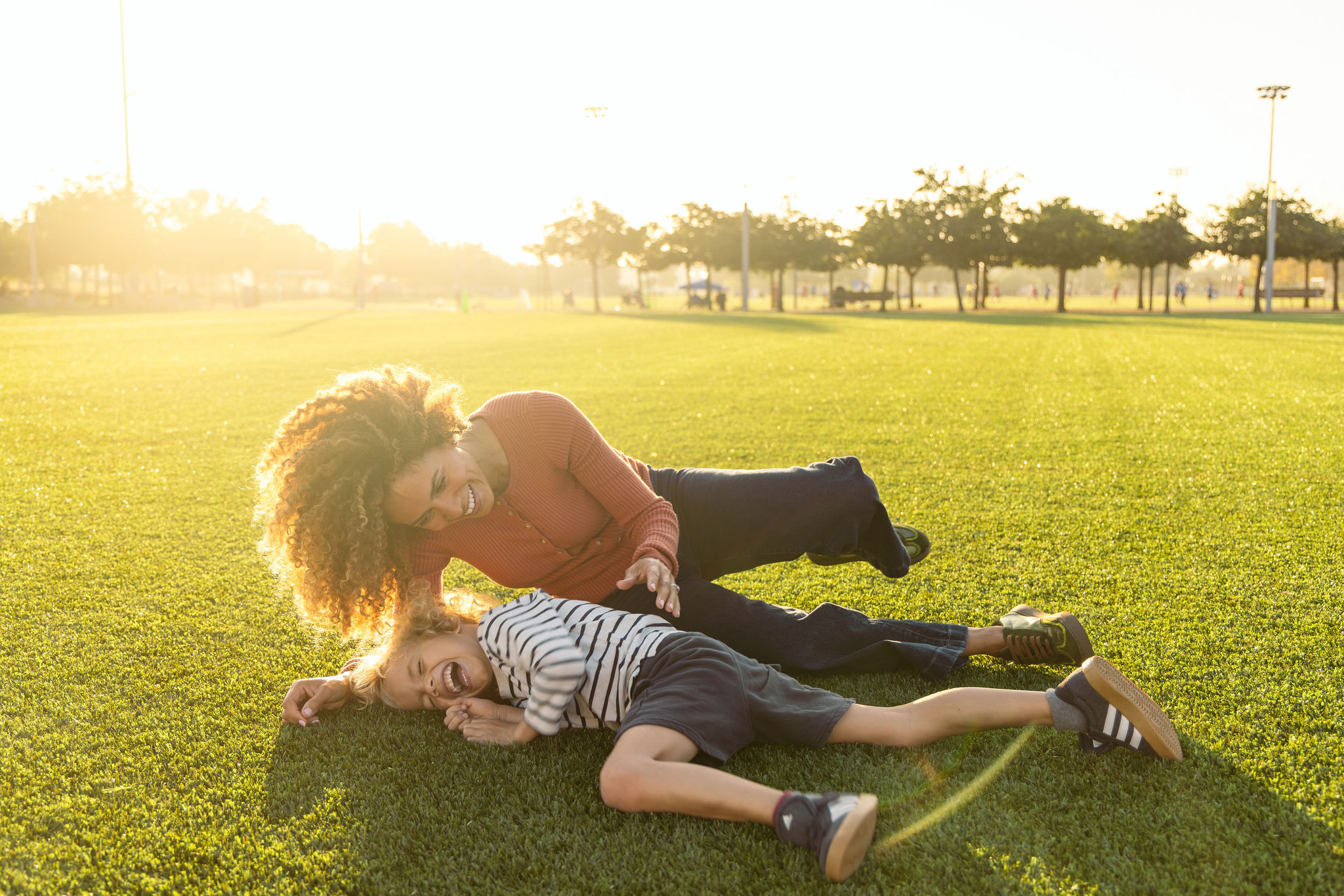 mother and son playing on a grassy field