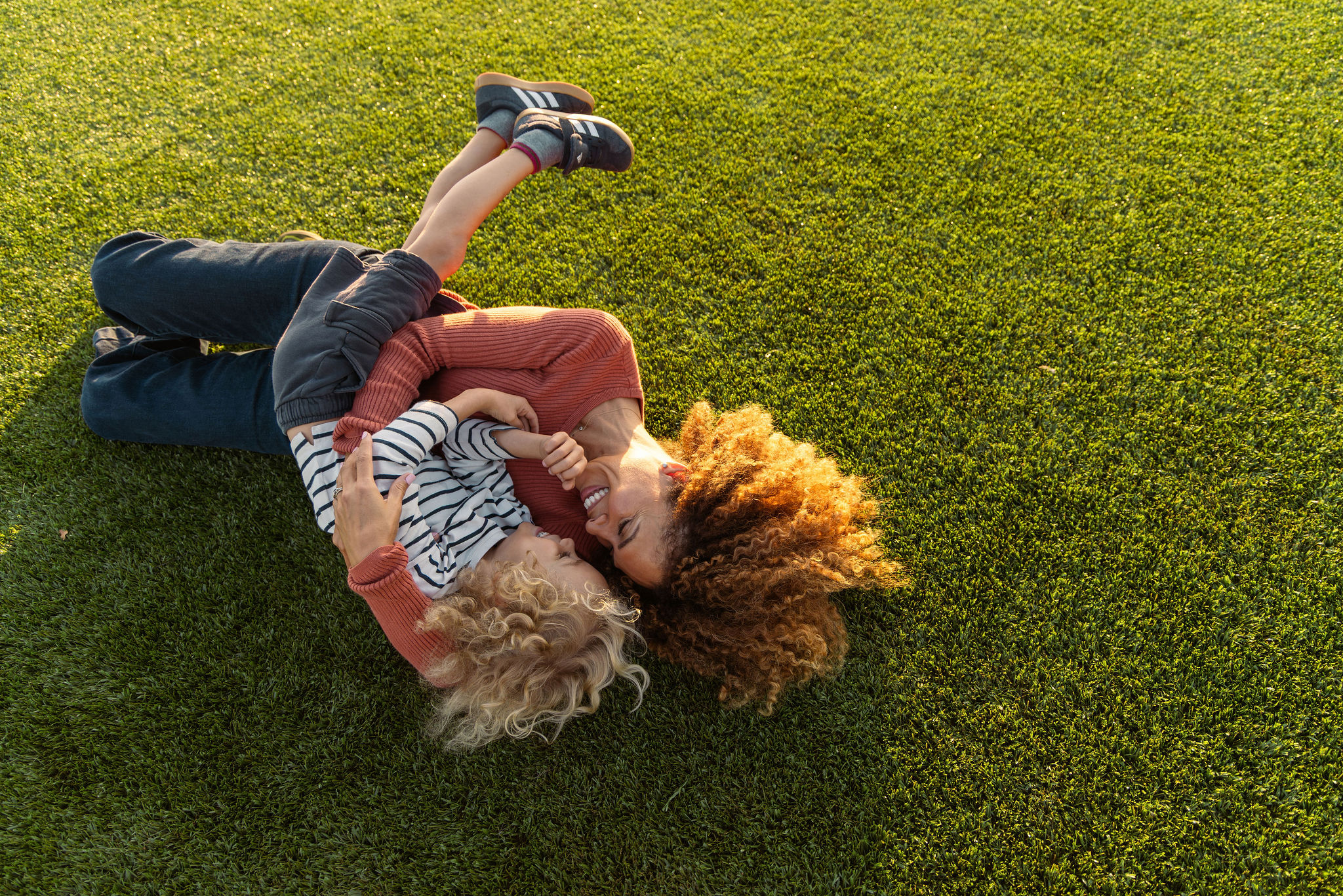 mother and son playing on a grassy field