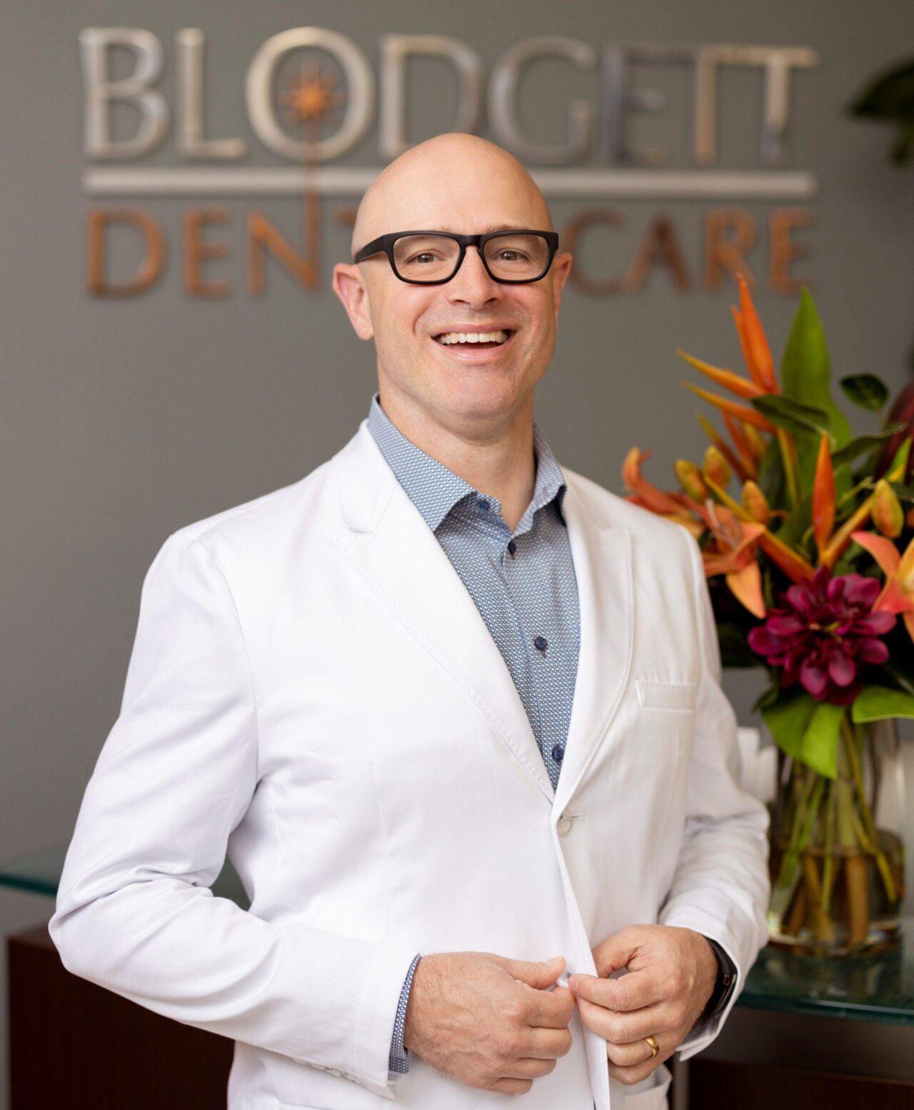 bald man with glasses in dentist's coat