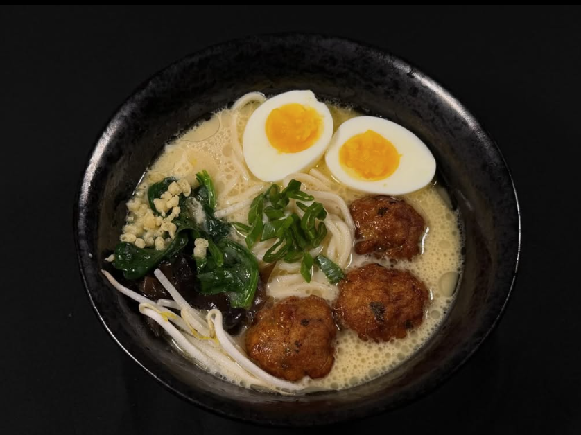 a bowl of ramen with egg and meatballs