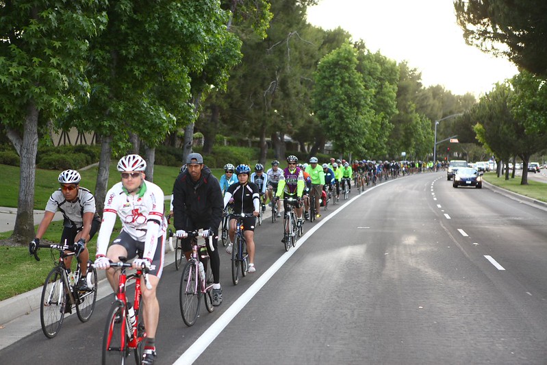 group of cyclists riding their bikes on a bike lane