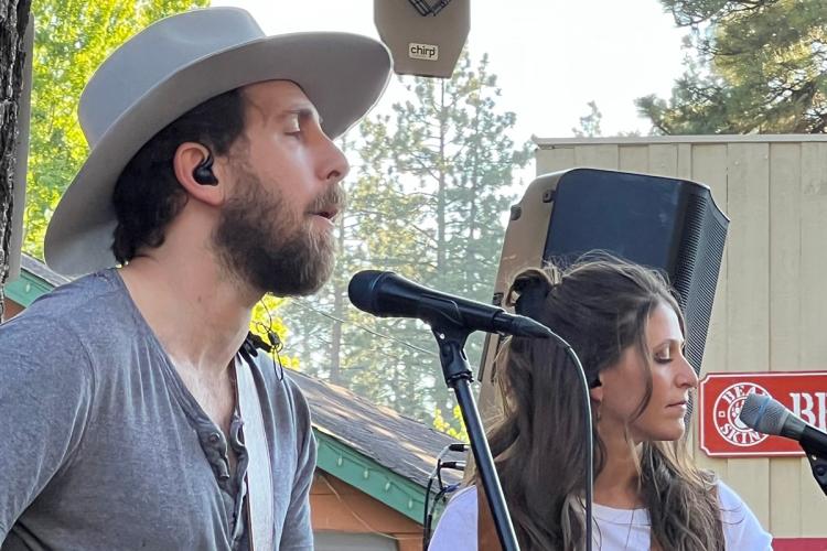 a male vocalist with hat and a female background performer