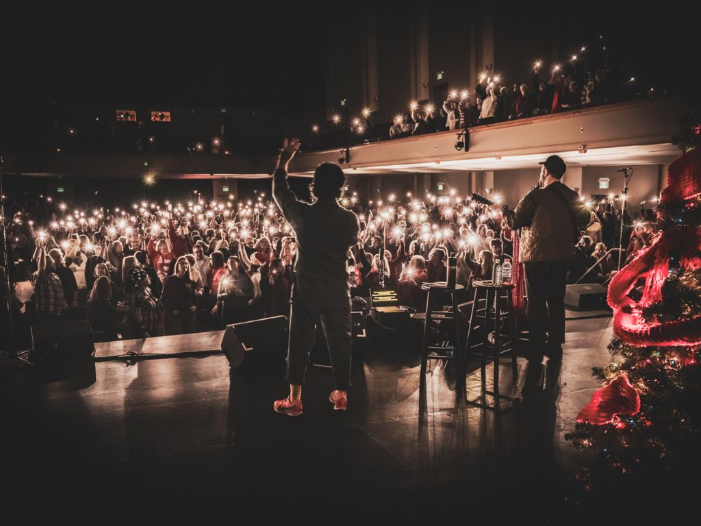 two performers on stage with a full audience