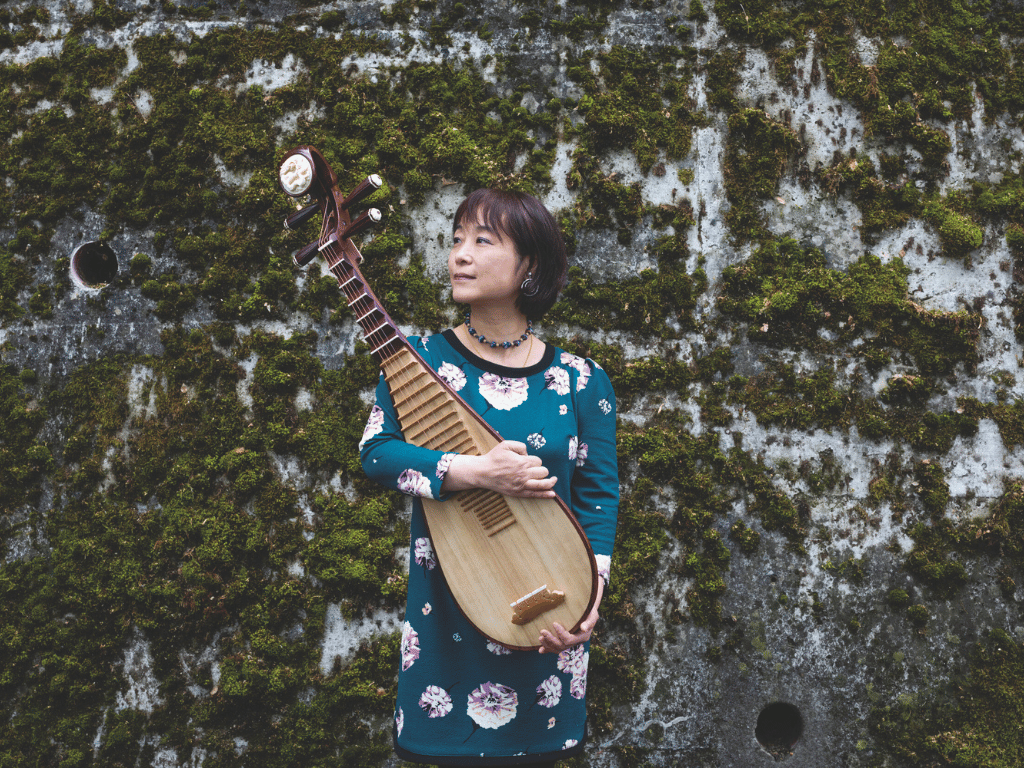 woman wearing a blue sweater with white print holding a banjo