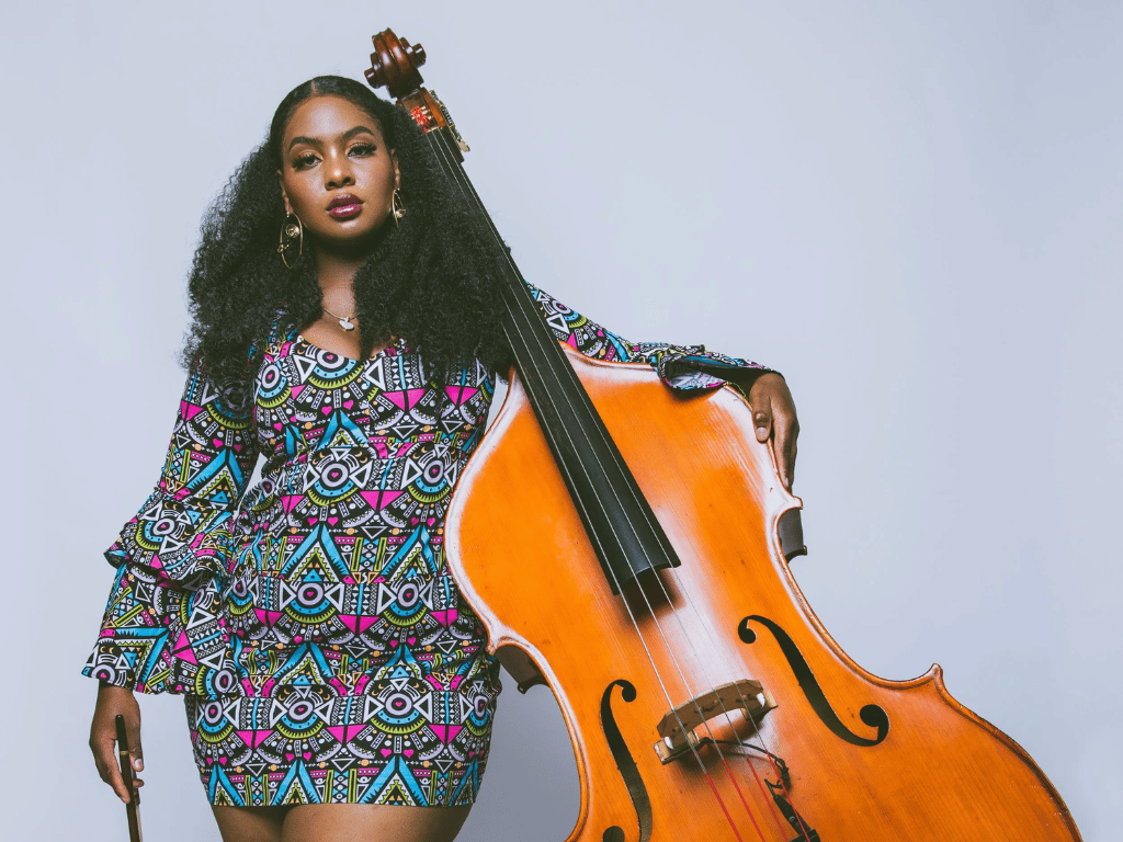 woman in printed colored dress holding a string bass