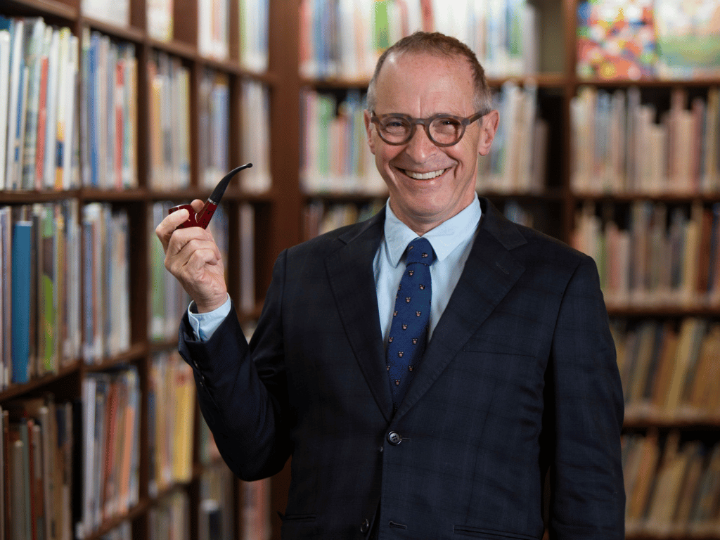 man with glasses in a dark suit and tie