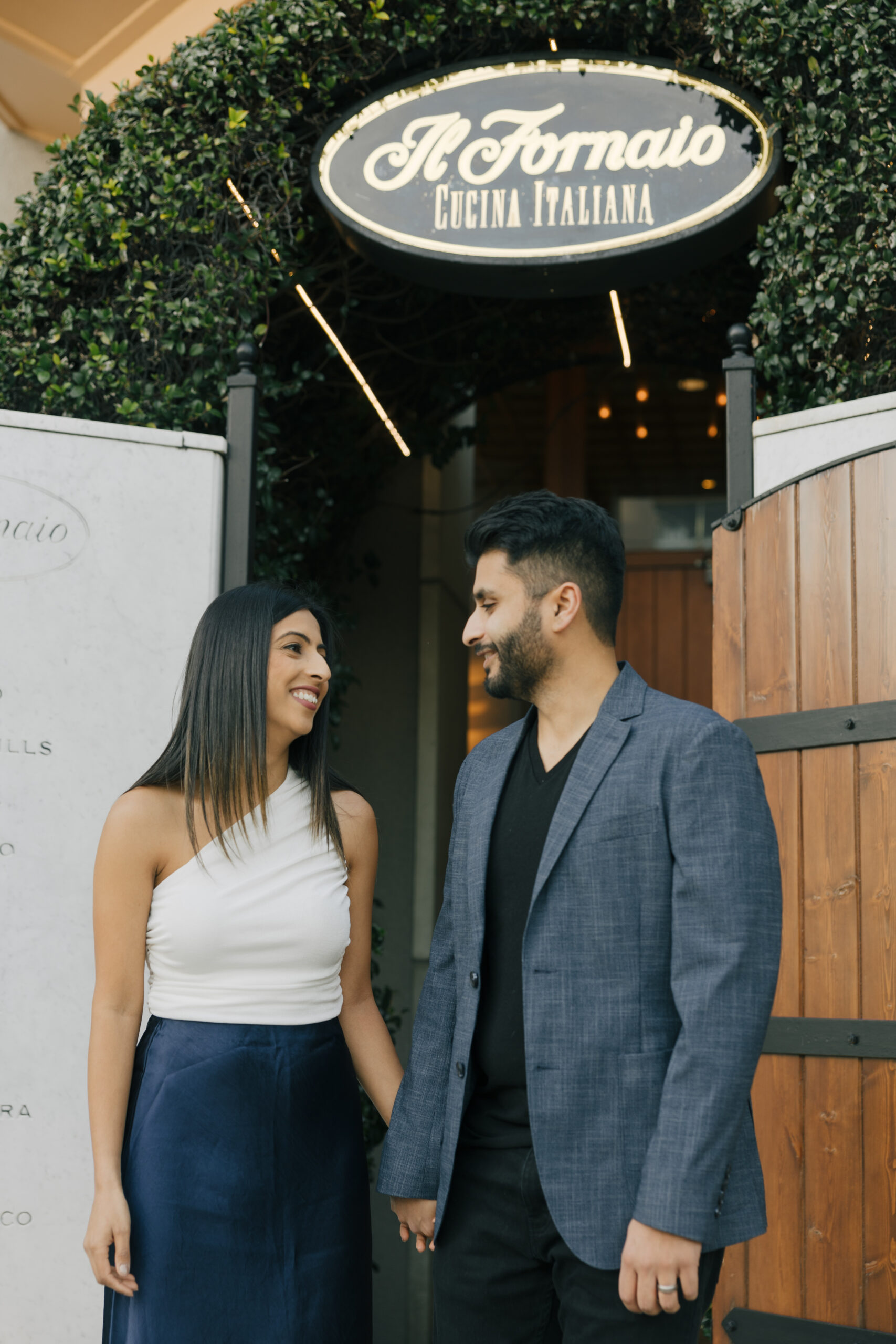 well dressed woman and man in front of a restaurant called Il Fornaio