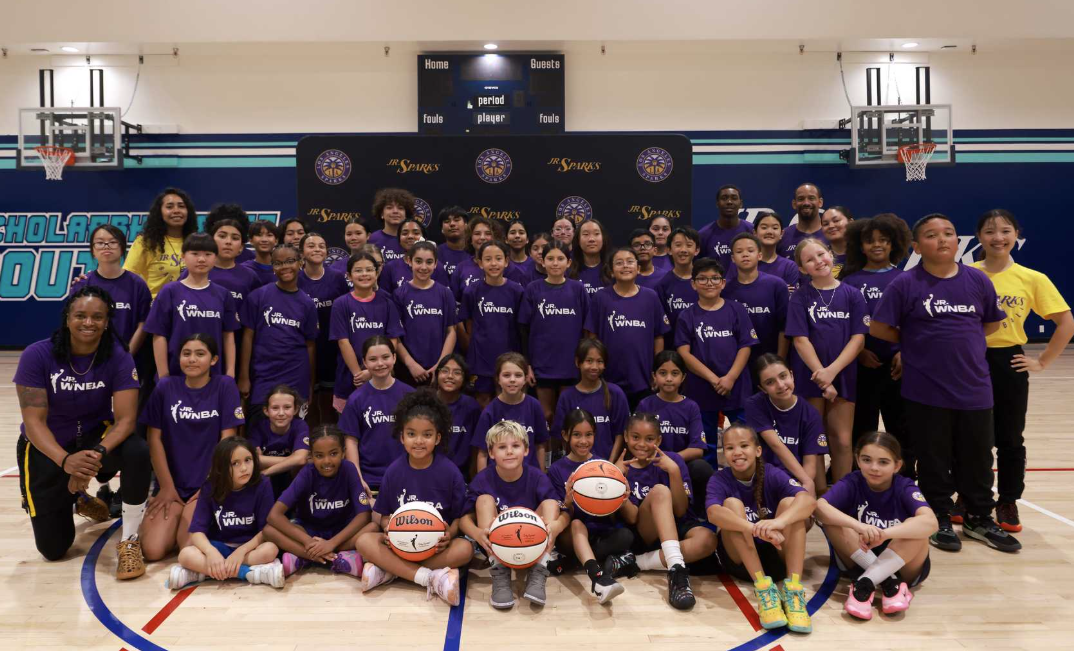 Group of girls in a basketball court posing for a group photo