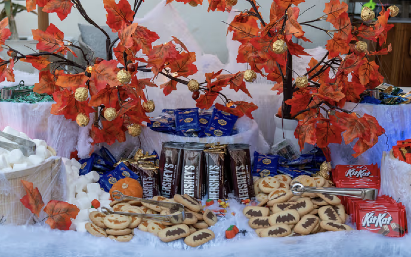 table with sweets and autumn leaves hanging